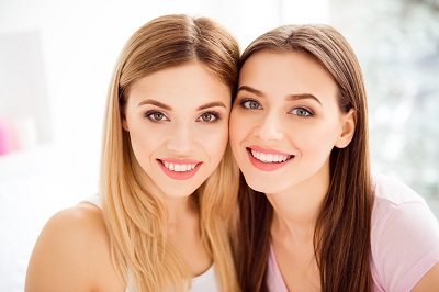 Close up portrait of two girls smiling