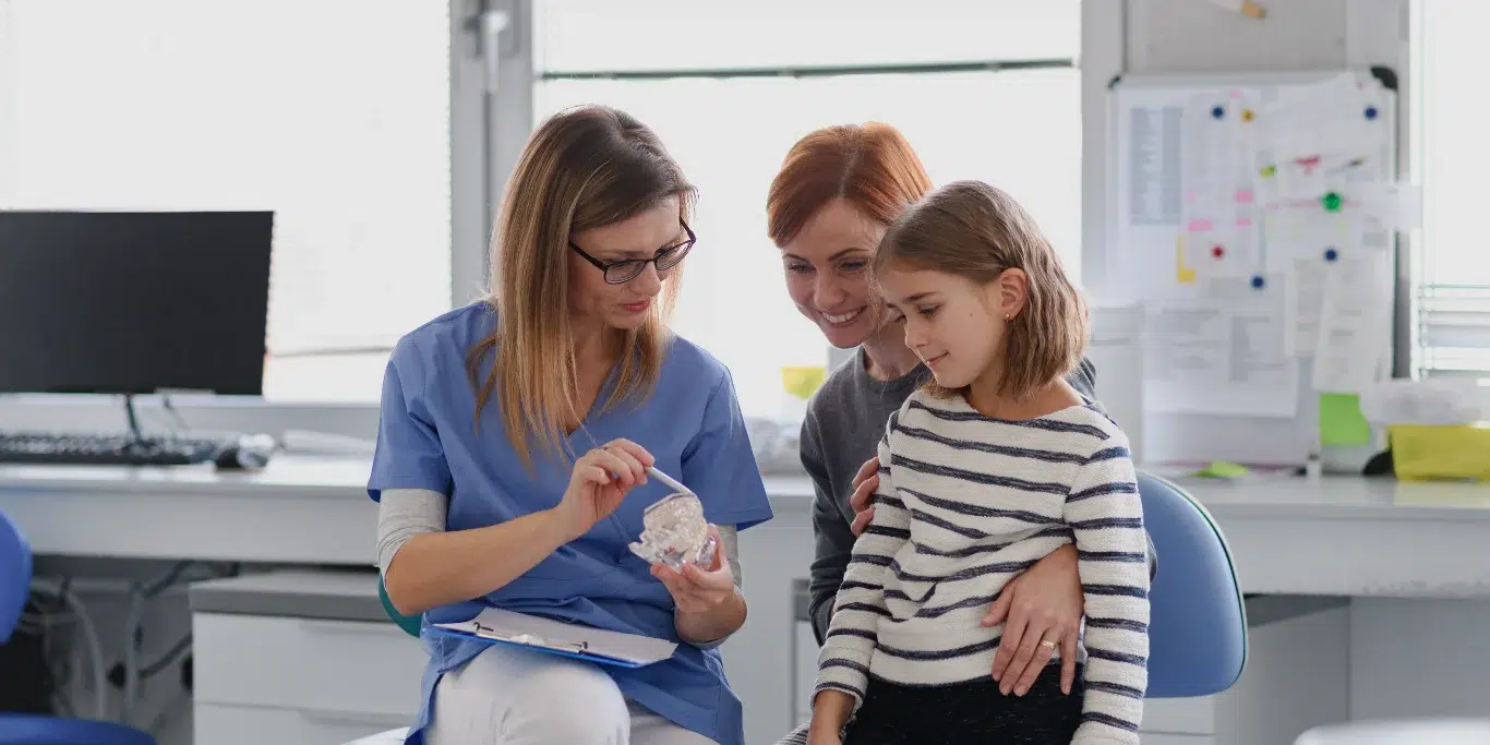 Girl showing her lost tooth to the dentist